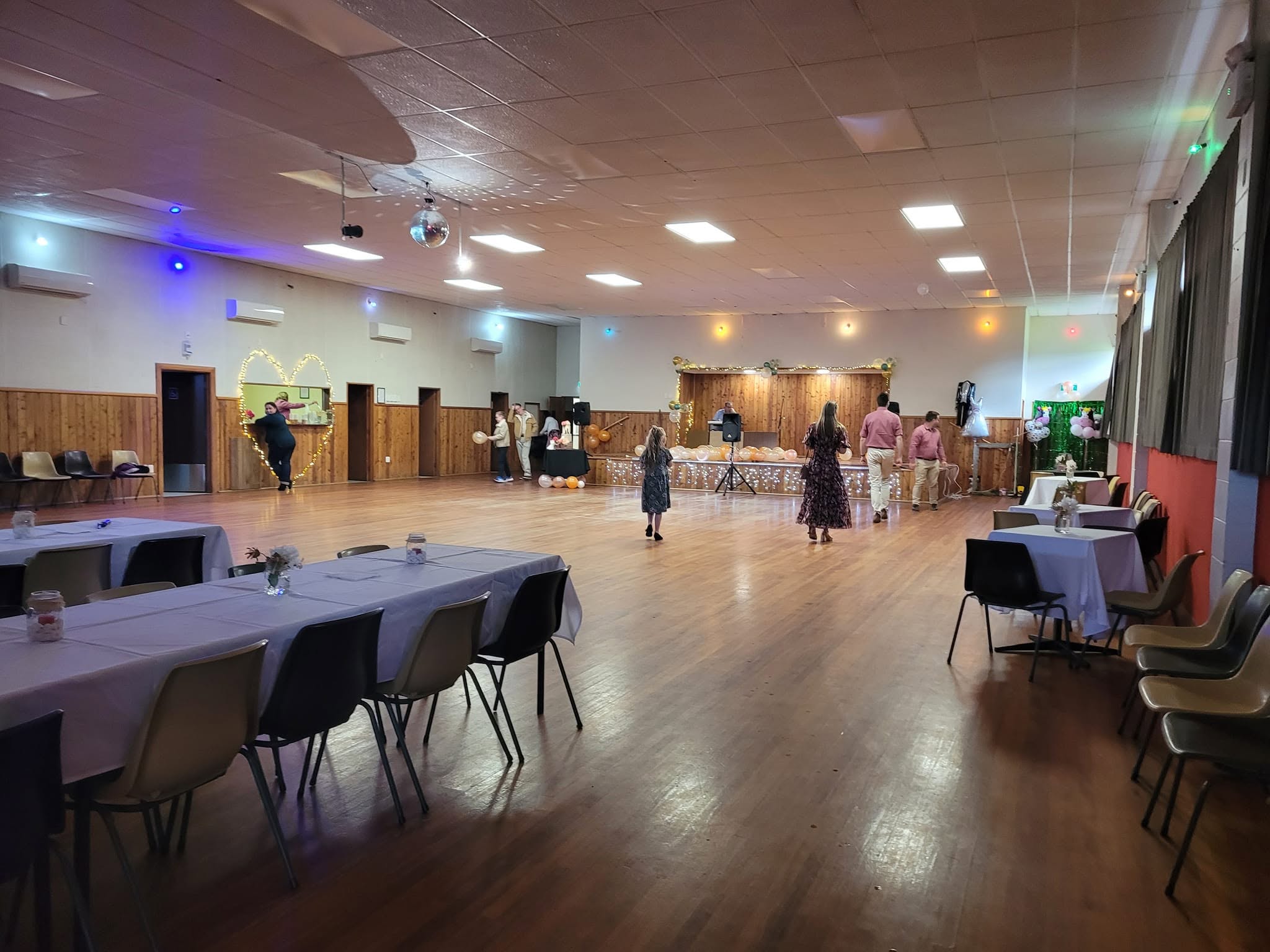Tables arranged around an open floor for a celebration at Wingatui Hall